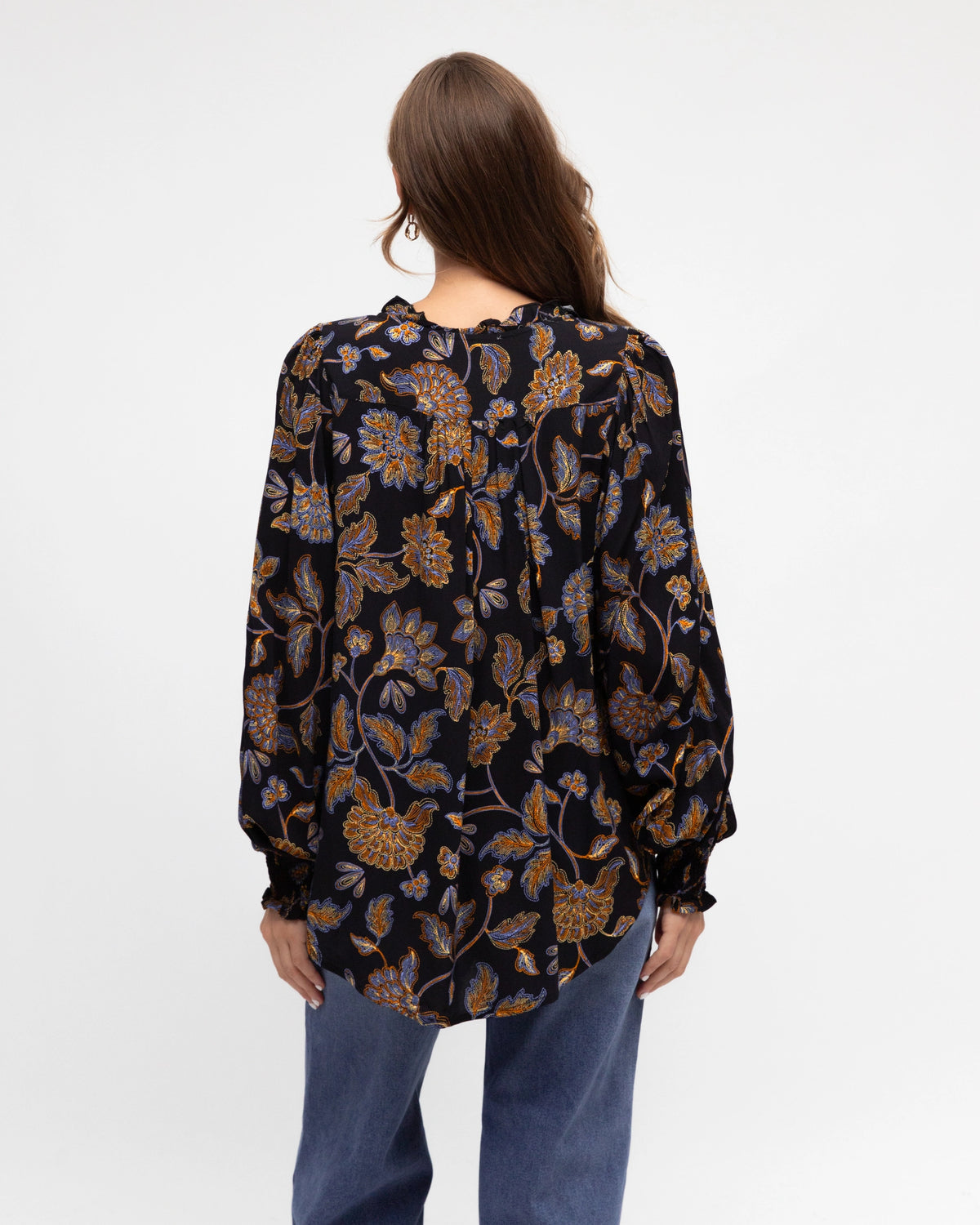 Woman wearing a black floral patterned shirt on a white background